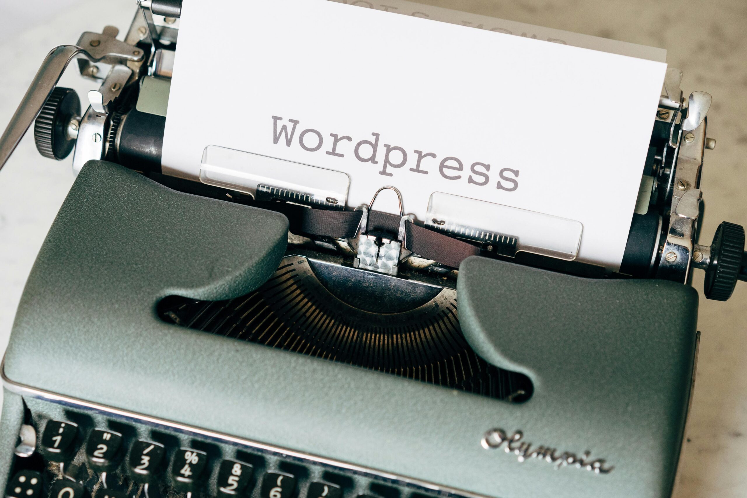 Close-up of a vintage typewriter with a paper displaying 'Wordpress' in retro style.